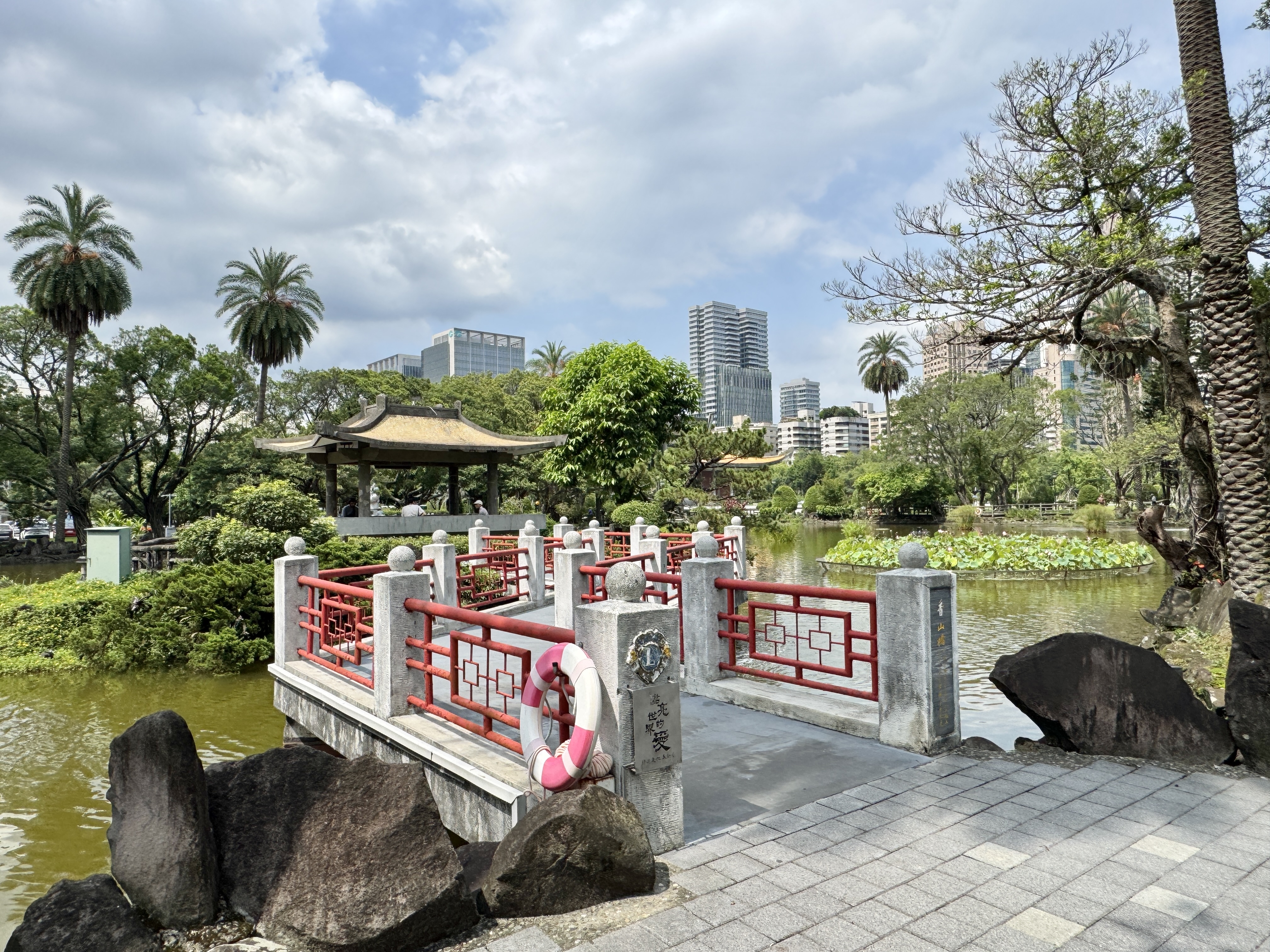 國父紀念館園區草地旁的樹木與步道，呈現舒適的戶外休憩環境。