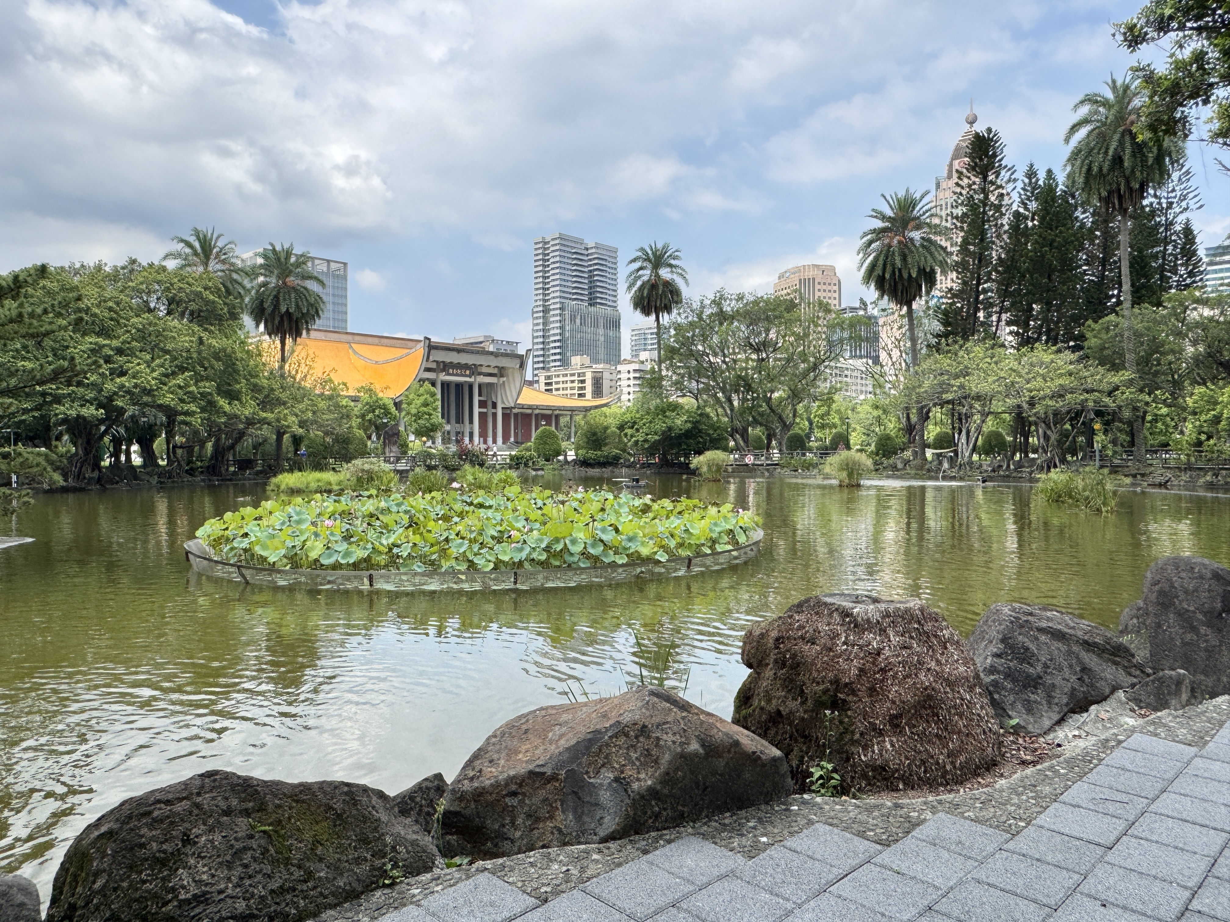 國父紀念館園區水池旁有綠地、樹木與倒影，環境安靜開闊。