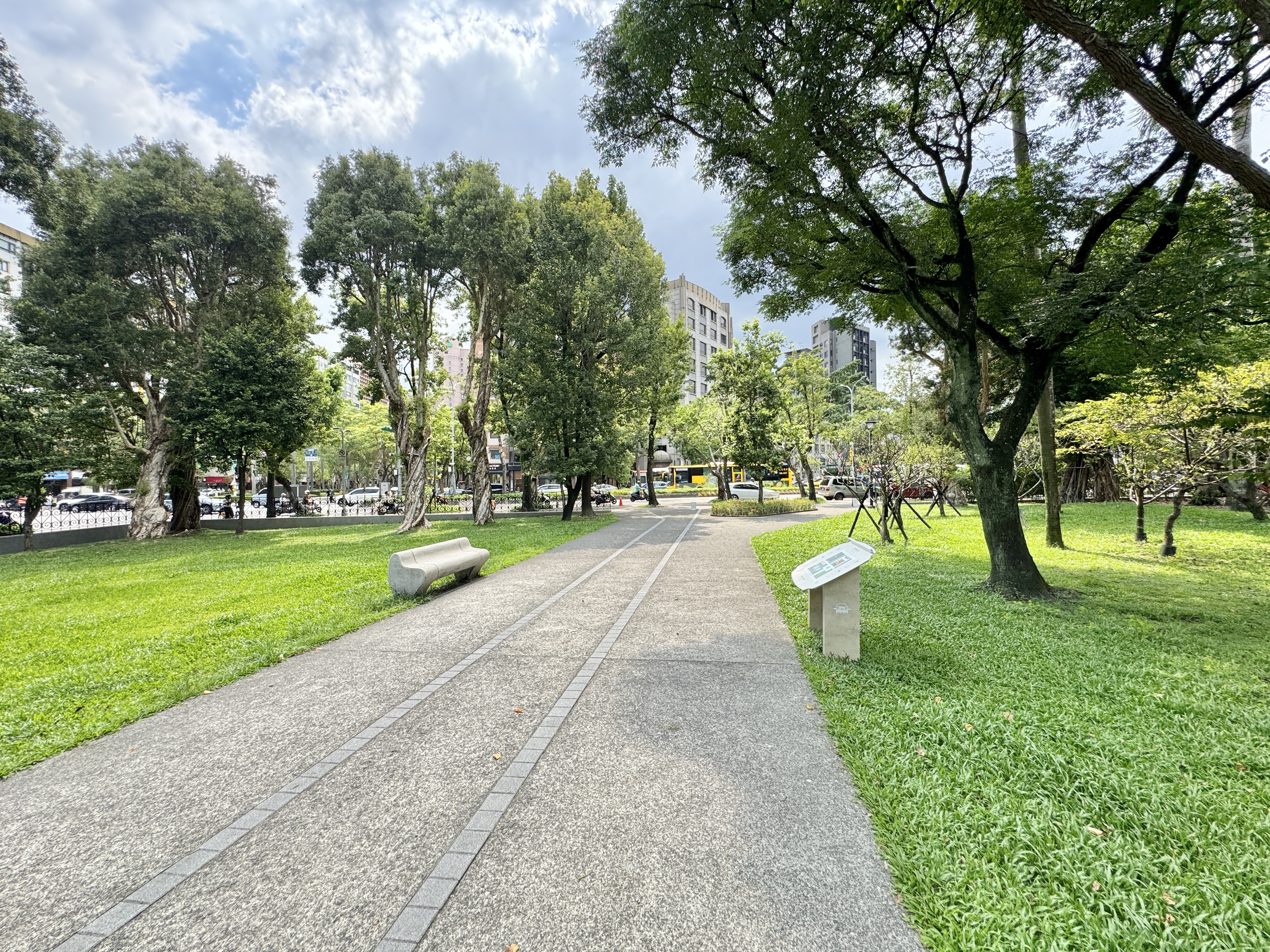 國父紀念館園區平整步道穿過草地，旁邊有樹木與綠地。