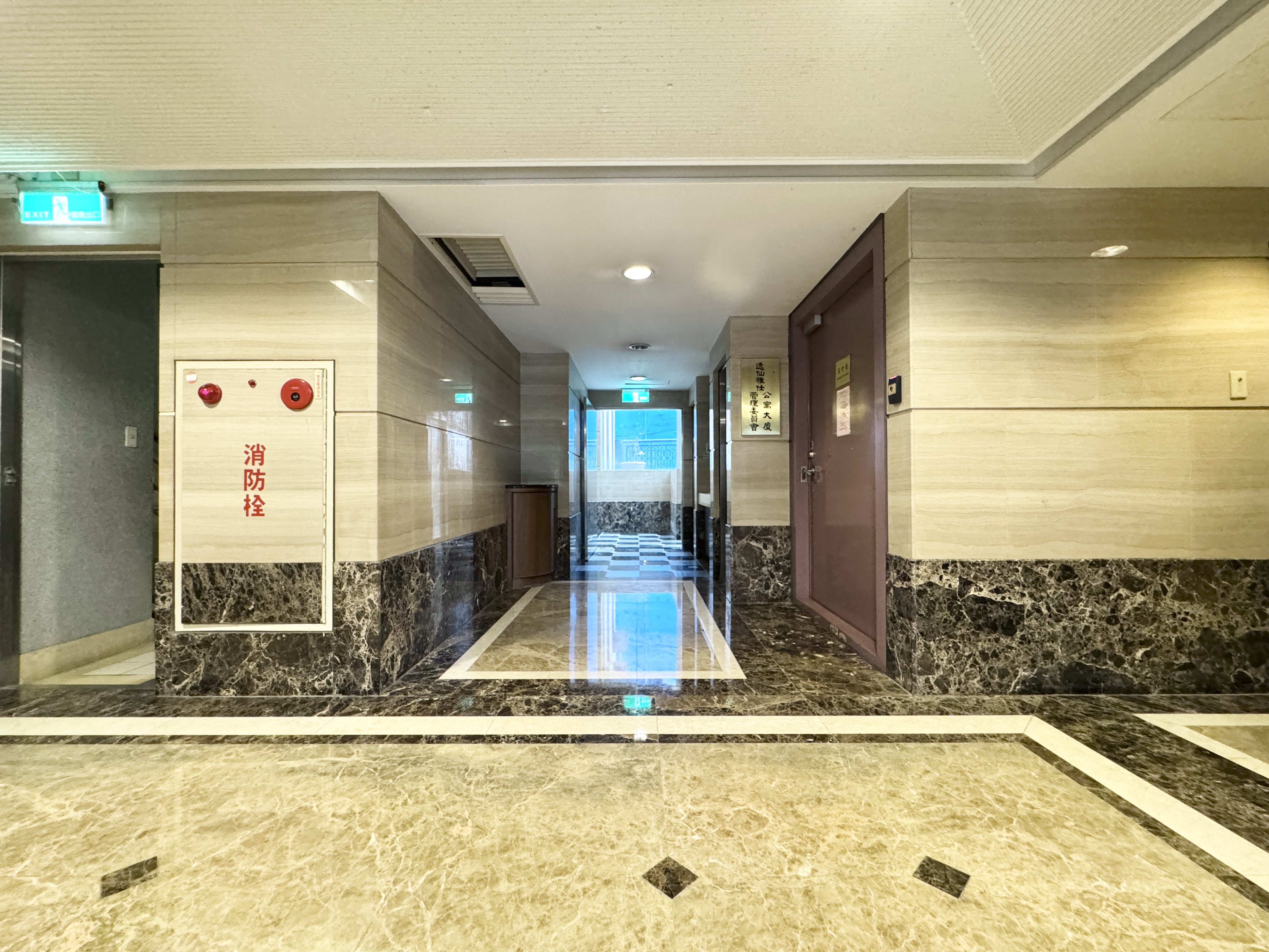 逸仙雅仕公設走廊入口，可見消防設備、照明與通往公共空間的走道。