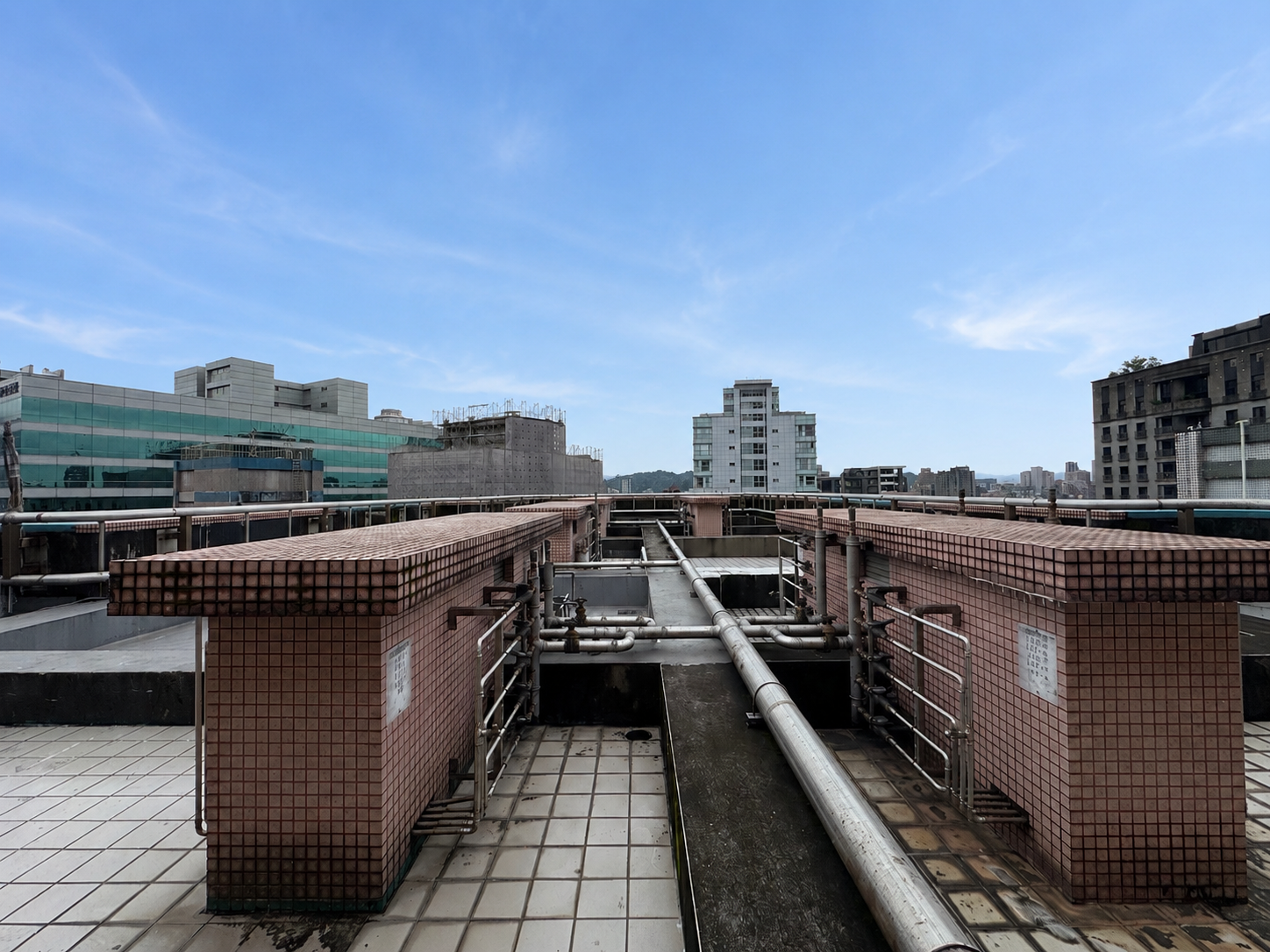 逸仙雅仕頂樓公共露臺，屋頂管線與周邊建築形成開闊視野。